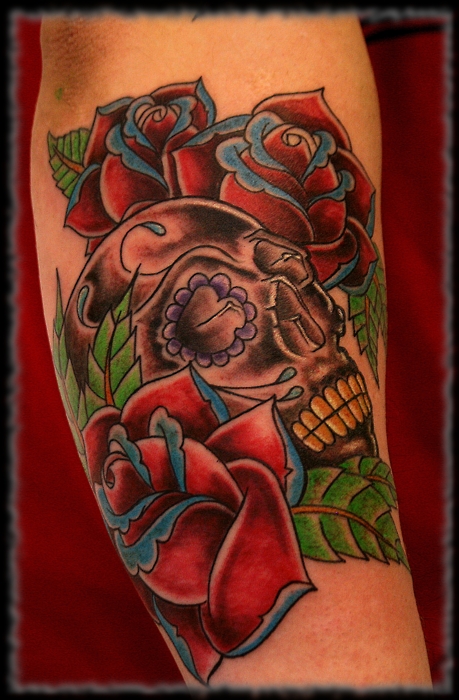 Colorful sugar skull tattoo with roses on arm