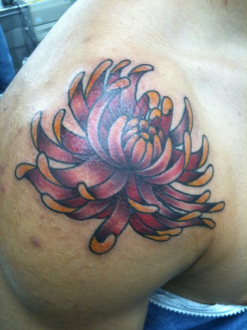 Daisy flowers tattoo located on the shoulder blade.