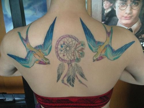 Colorful swallow tattoos around a dreamcatcher