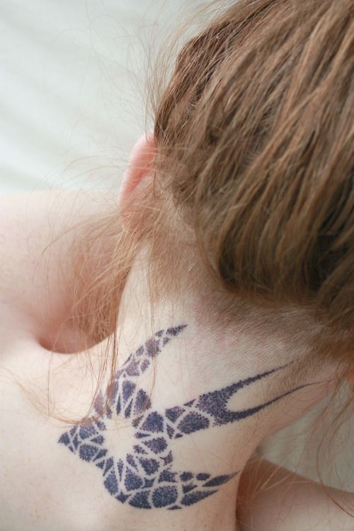 Tribal dotted sparrow tattoo on back of girl’s neck