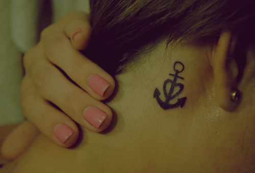 Black anchor tattoo with heart behind girls ear