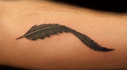 Black feather tattoo on guys arm