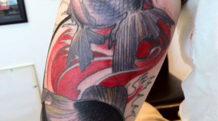 Black fish arm tattoo