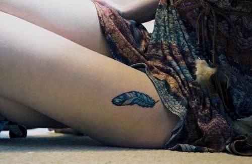 Blue and white feather on girls thigh