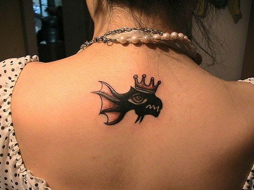 Cool goldfish tattoo with crown on girls back