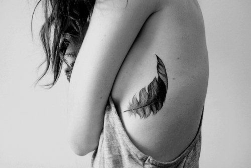 Floating feather tattoo on girls side