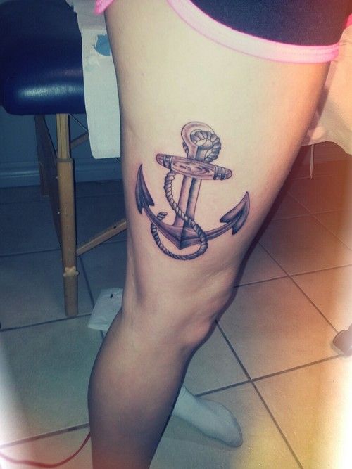 Large black traditional anchor tattoo on girl’s thigh