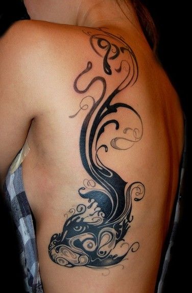 Large black tribal fish tattoo on back of girls shoulder