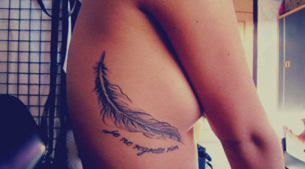 Large feather tattoo on girls side with quote
