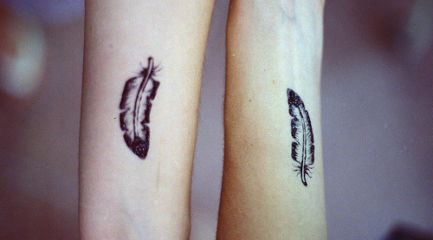 Matching best friends feather tattoos on wrists