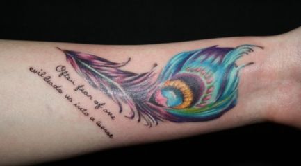 Peacock feather tattoo with quote on arm