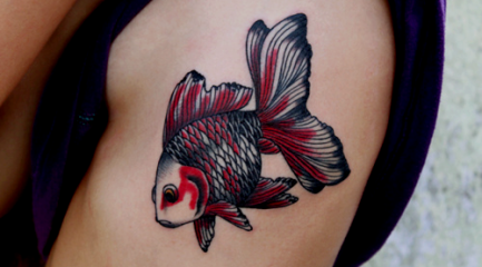 Red and black goldfish arm tattoo