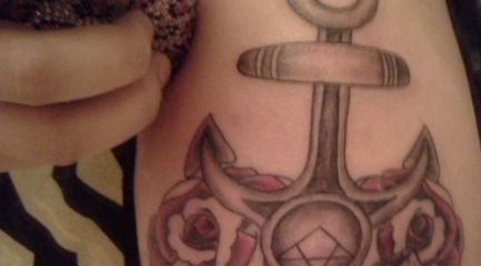 Religious anchor tattoo with roses on girls arm