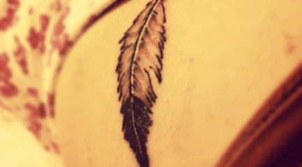 Simple back and white ruffled feather tattoo