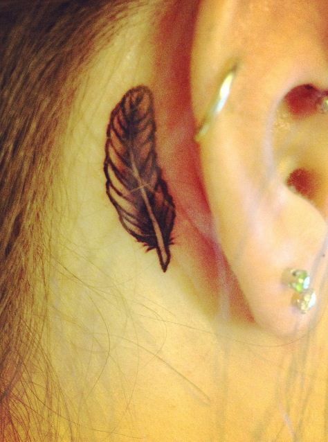 Small black behind the ear feather tattoo
