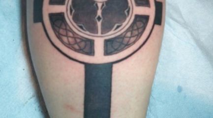 Black Celtic cross leg tattoo