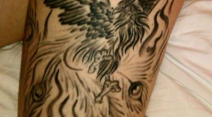 Black phoenix and sun tattoo on girls leg