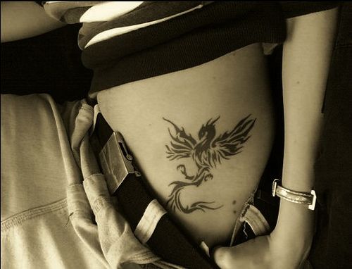 Black phoenix tattoo on girls waist
