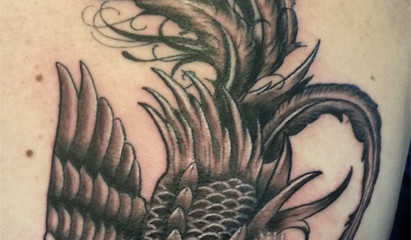 Detailed black phoenix tattoo on girls back