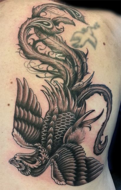 Detailed black phoenix tattoo on girls back