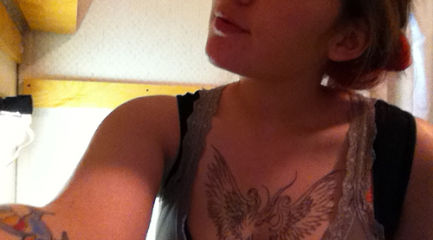 Girls black phoenix tattoo on her chest