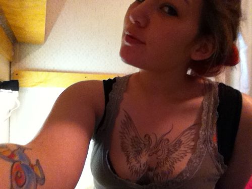 Girls black phoenix tattoo on her chest