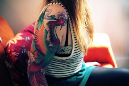 Girls colorful phoenix tattoo on her arm