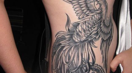 Phoenix rising tattoo on girls side in black