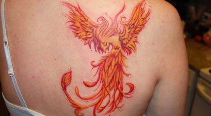 Phoenix tattoo on back of girls shoulder in fire colors