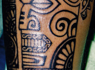 Polynesian totem face tattoo on guys leg