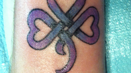 Purple Celtic shamrock tattoo on wrist