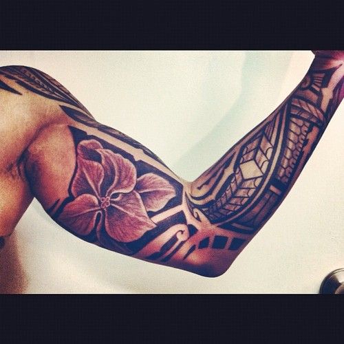 Shoulder and sleeve Polynesian tattoo with flower