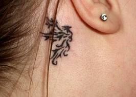Small tribal phoenix tattoo behind girls ear