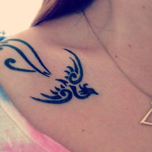 Small tribal phoenix tattoo on girls shoulder